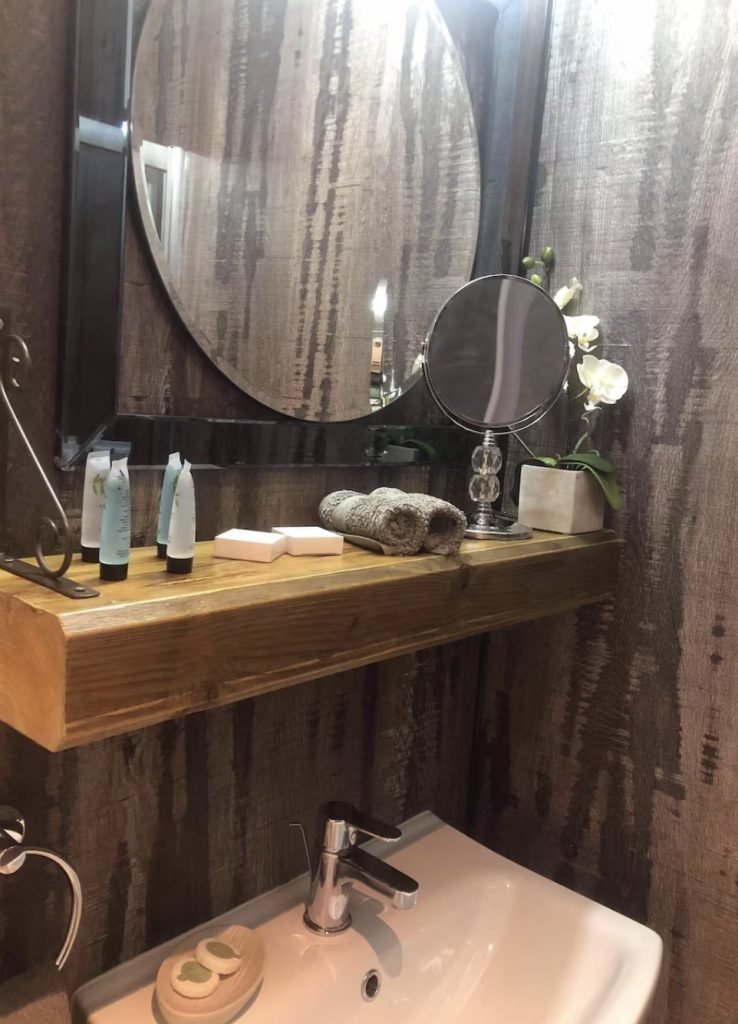 Bathroom basin and mirror with toiletries at King Street Holiday Apartment, Inverness